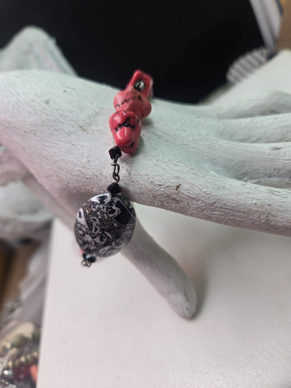 bohemian-style bracelet featuring chunky red magnesite stones and a black